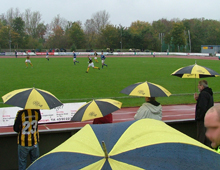Brønshøj-tilhængere med sort-gule paraplyer i møgvejret i Greve (foto: S. Lillie)