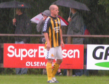 Mads Westh, Brønshøj, i silende regn med paraplybærende tilskuere i baggrunden (foto: T. Brygger)