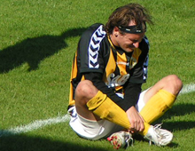 Jesper Duelund, Brønshøj, sidder på banen og ømmer sig efter en hård tackling i hjemmekampen mod HIK lørdag 16. august 2008 (foto: T. Brygger) 