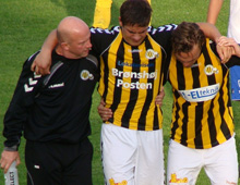 Lasse Fosgaard, Brønshøj Boldklub, støttes fra banen af Poul Olesen (tv) og Pierre Kanstrup (th) efter at være blevet skadet i pokalopgøret ude mod Herlev 31. august 2011 (foto: T. Brygger)